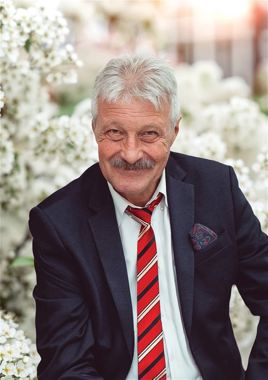 Oleg Sedlețchi, zâmbind, în costum și cravată roșie